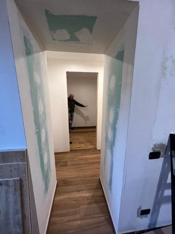 Un uomo è in piedi in mezzo a un corridoio.