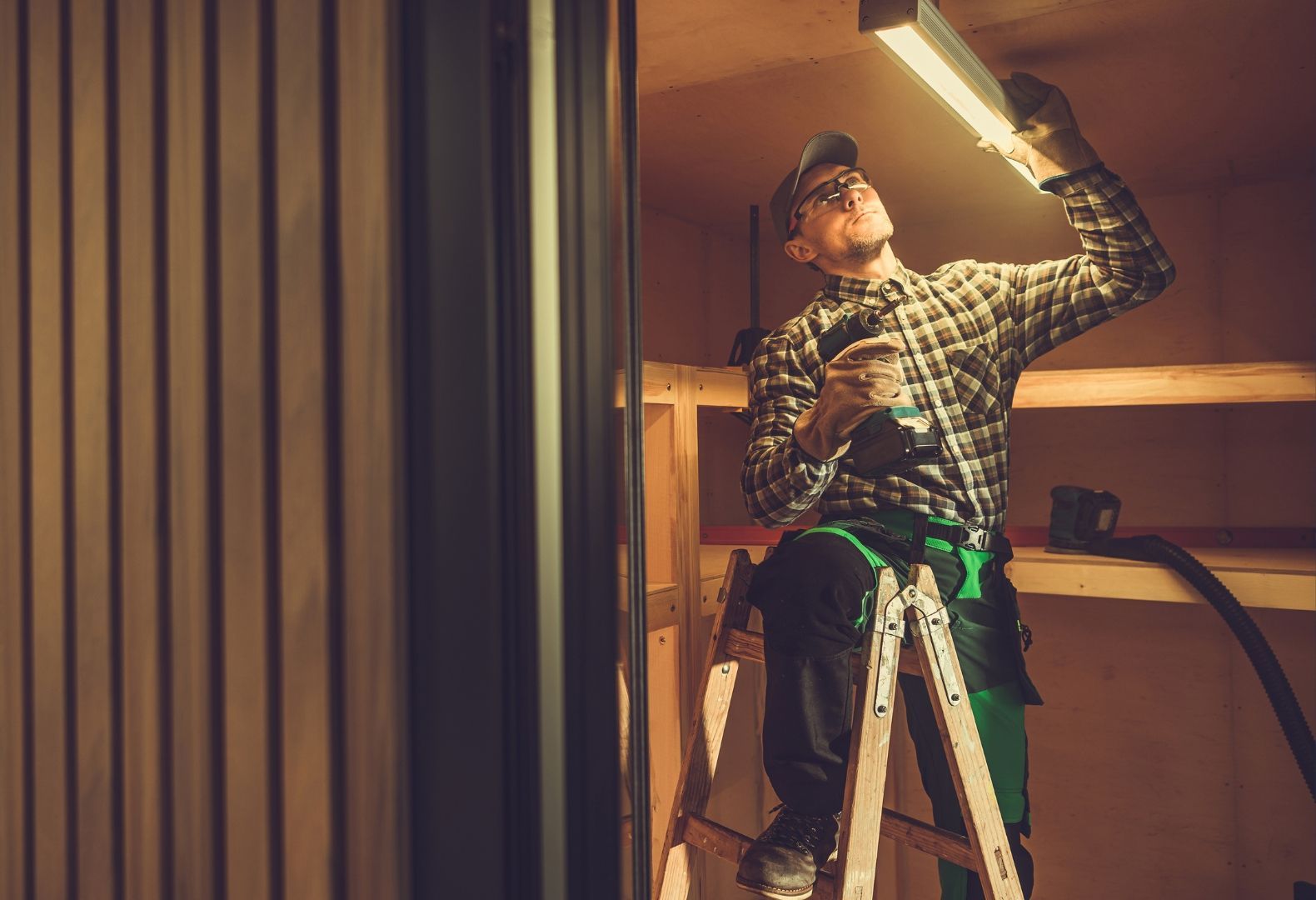 A man is working on a boiler with a wrench.