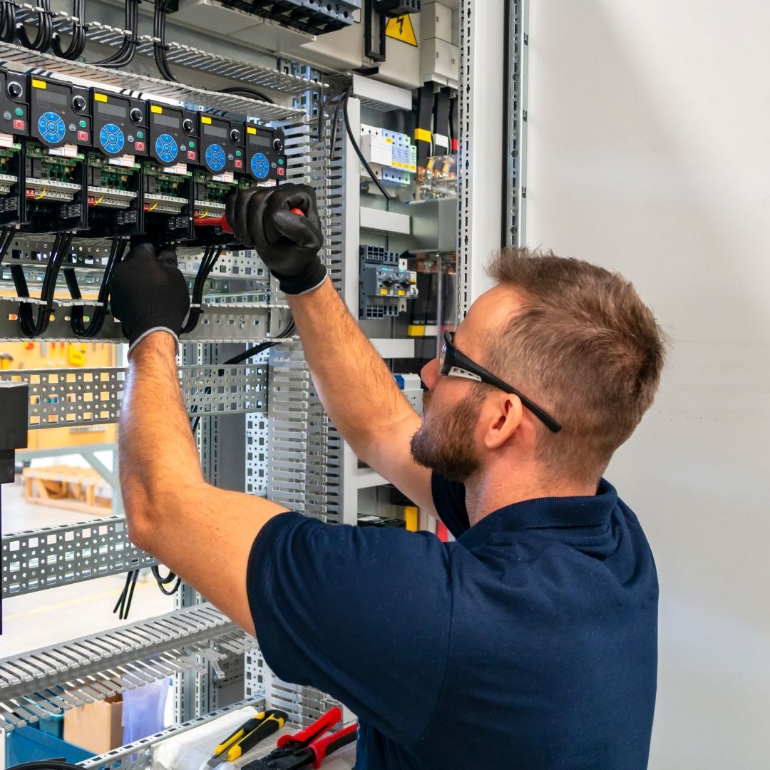 A man is working on a light bulb in a room.