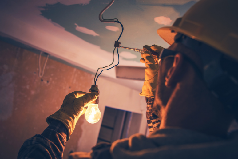 A man is working on a light bulb in a room.