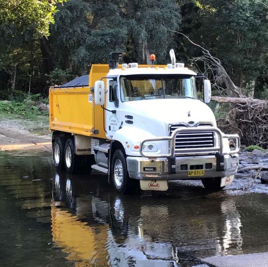 White and Yellow Tipper Truck Parked Near a Creek — B & D Bunt Earthmoving Contractors in North Boambee Valley, NSW