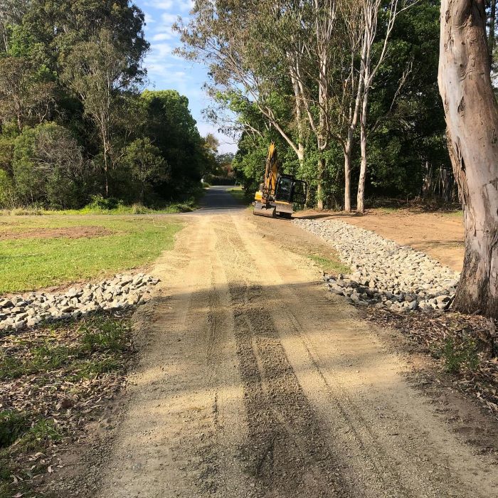 A Dirt Road With Excavator — B & D Bunt Earthmoving Contractors in North Boambee Valley, NSW