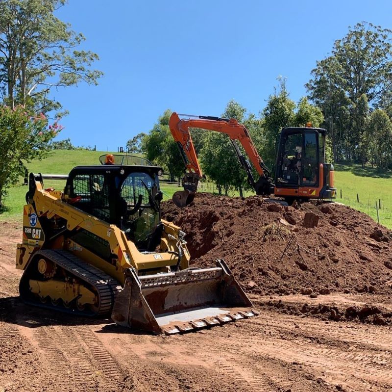 A Yellow Skid Steer and Orange Excavator — B & D Bunt Earthmoving Contractors in Coffs Harbour, NSW