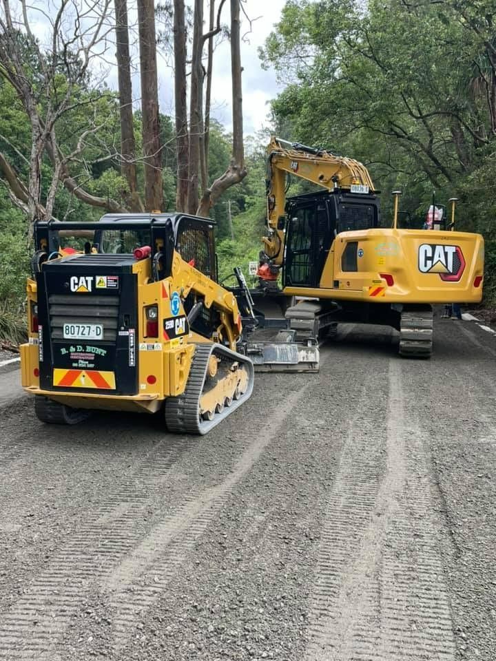 A Two Excavator and Skid Steer on a Road — B & D Bunt Earthmoving Contractors in North Boambee Valley, NSW