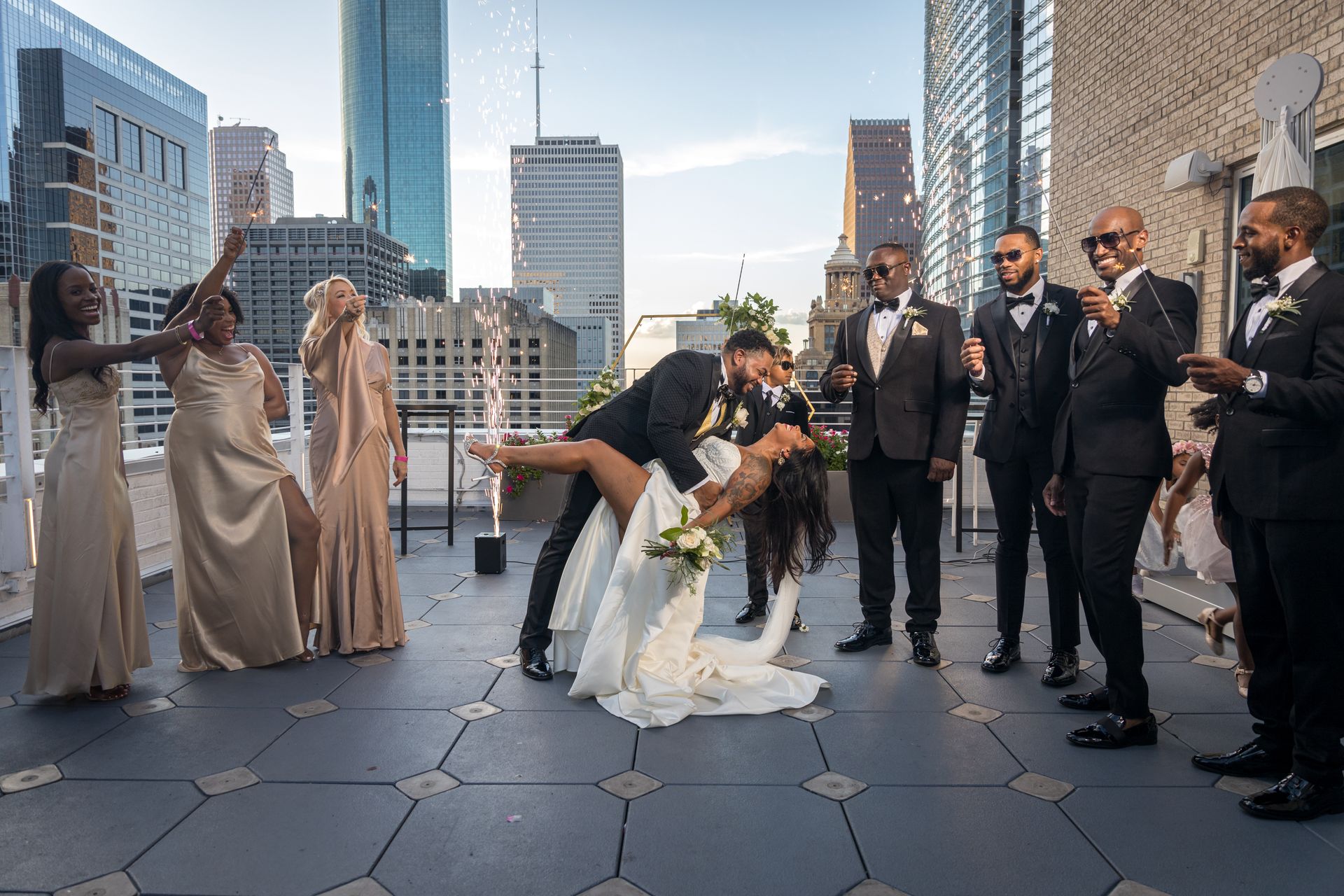A man is kneeling next to a pregnant woman in a pink dress.