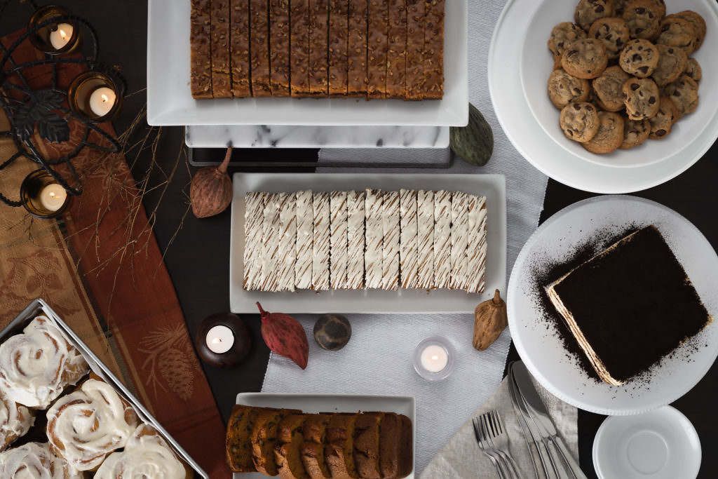 A table topped with a variety of desserts including cookies and cinnamon rolls