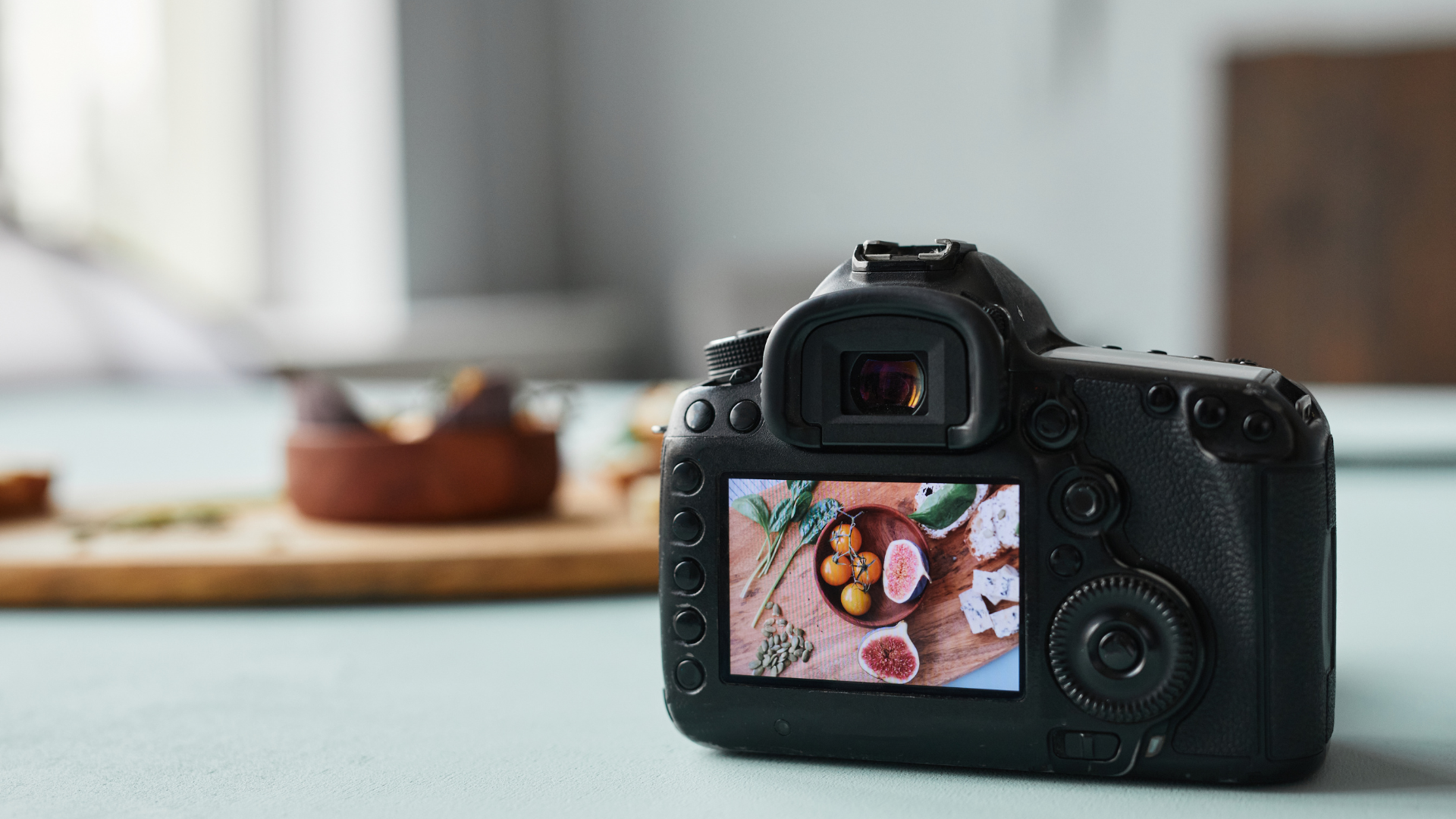 A close up of a camera taking a picture of food on a table.