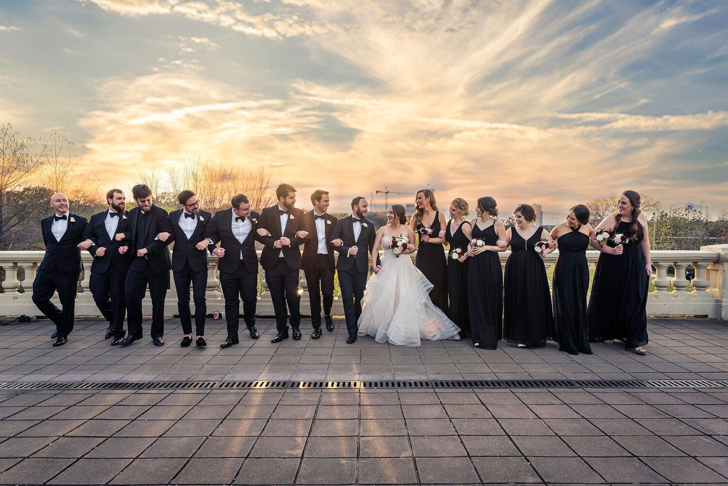 The bride and groom are posing for a picture with their wedding party.