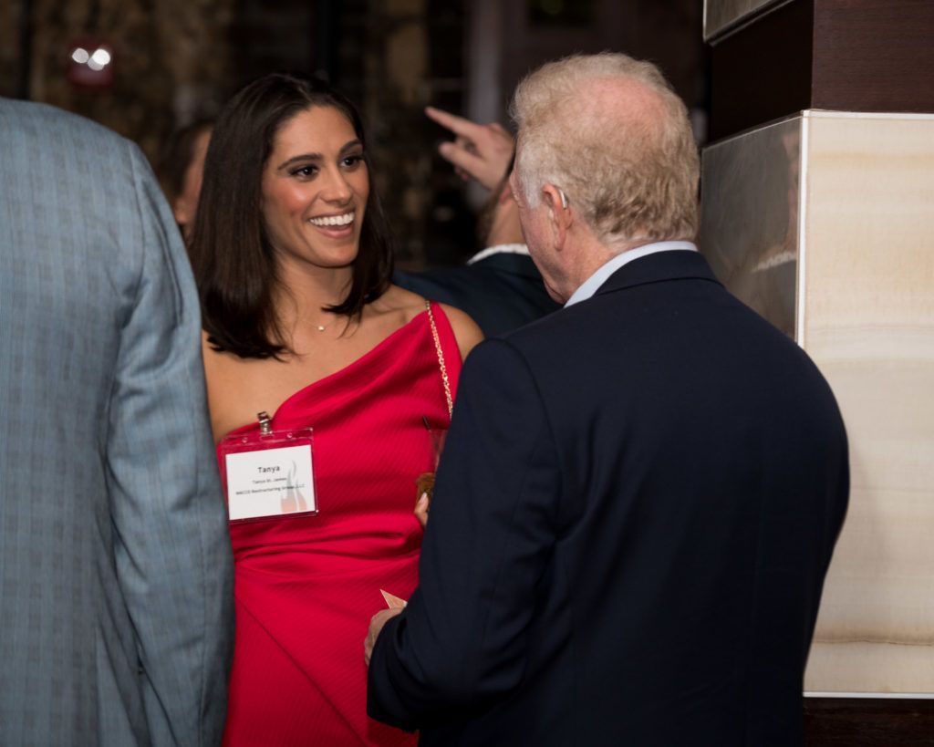 A woman in a red dress is talking to a man in a suit