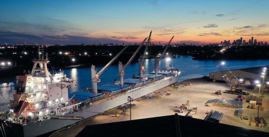 A large ship is docked in a harbor at night.