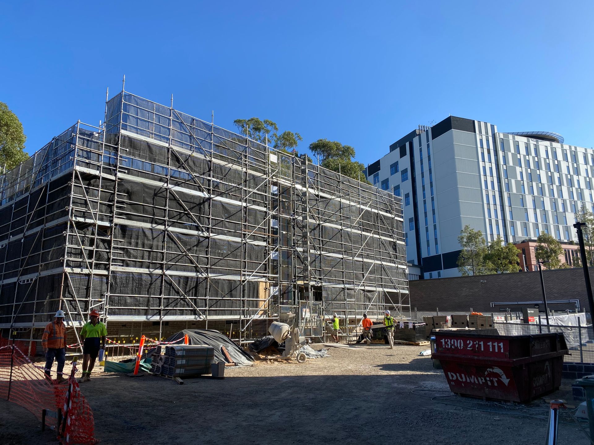 A large building under construction with scaffolding and a crane.