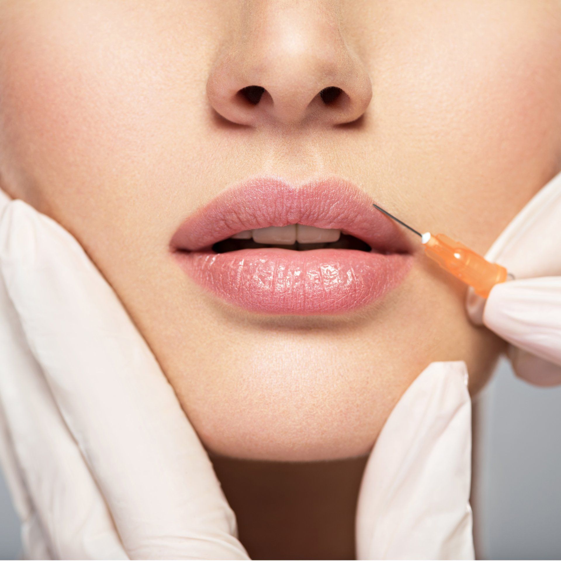 A woman is getting a botox injection in her lips.