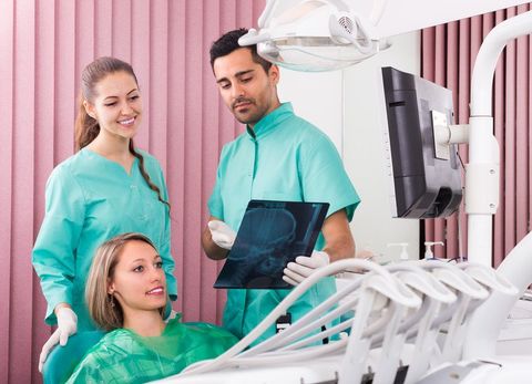 Dentist and female patient looking an x-ray image in dental clinic