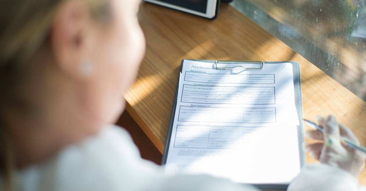A woman is sitting at a desk with a clipboard and a pen.