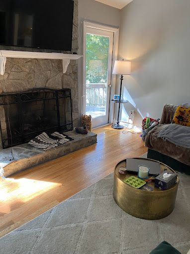 A living room with a fireplace , couch , coffee table and television.