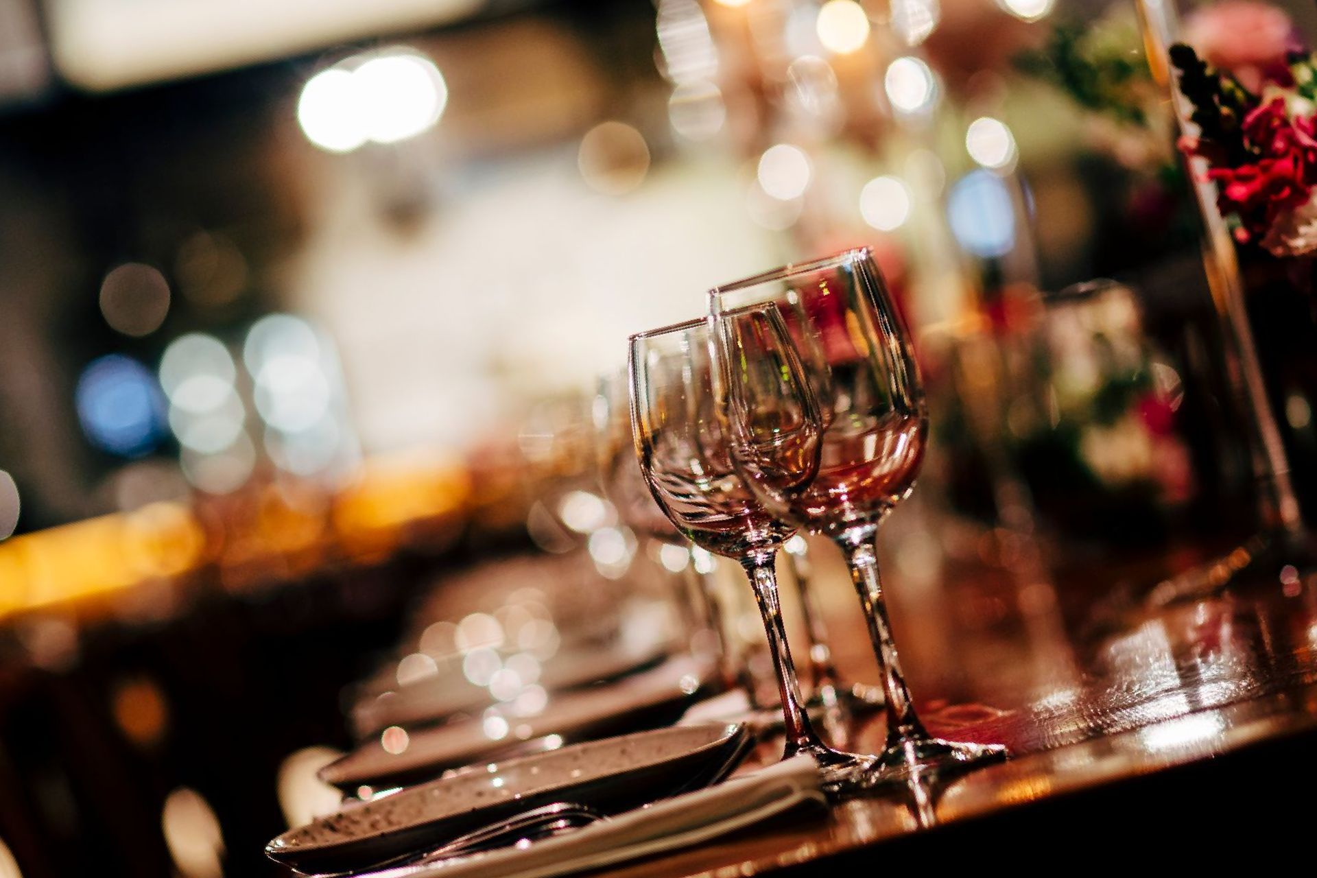 Una fila di bicchieri di vino seduti sopra un tavolo di legno.