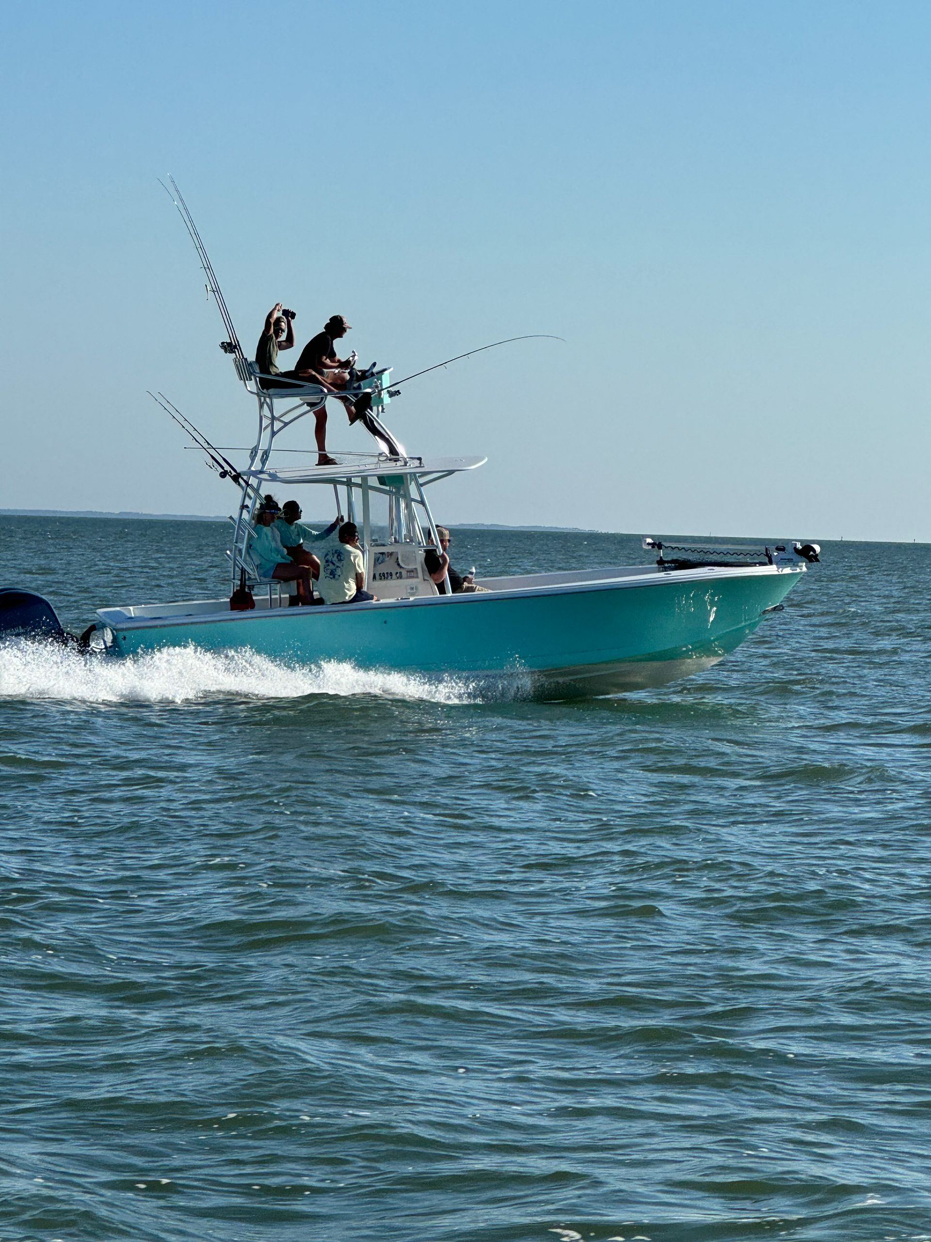 A blue boat is floating on top of a body of water