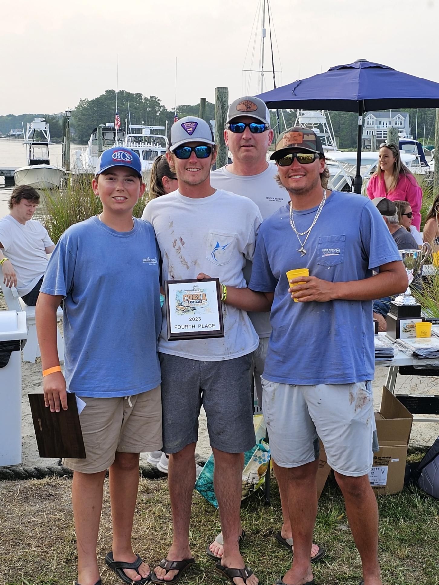 A group of men standing next to each other holding a plaque.