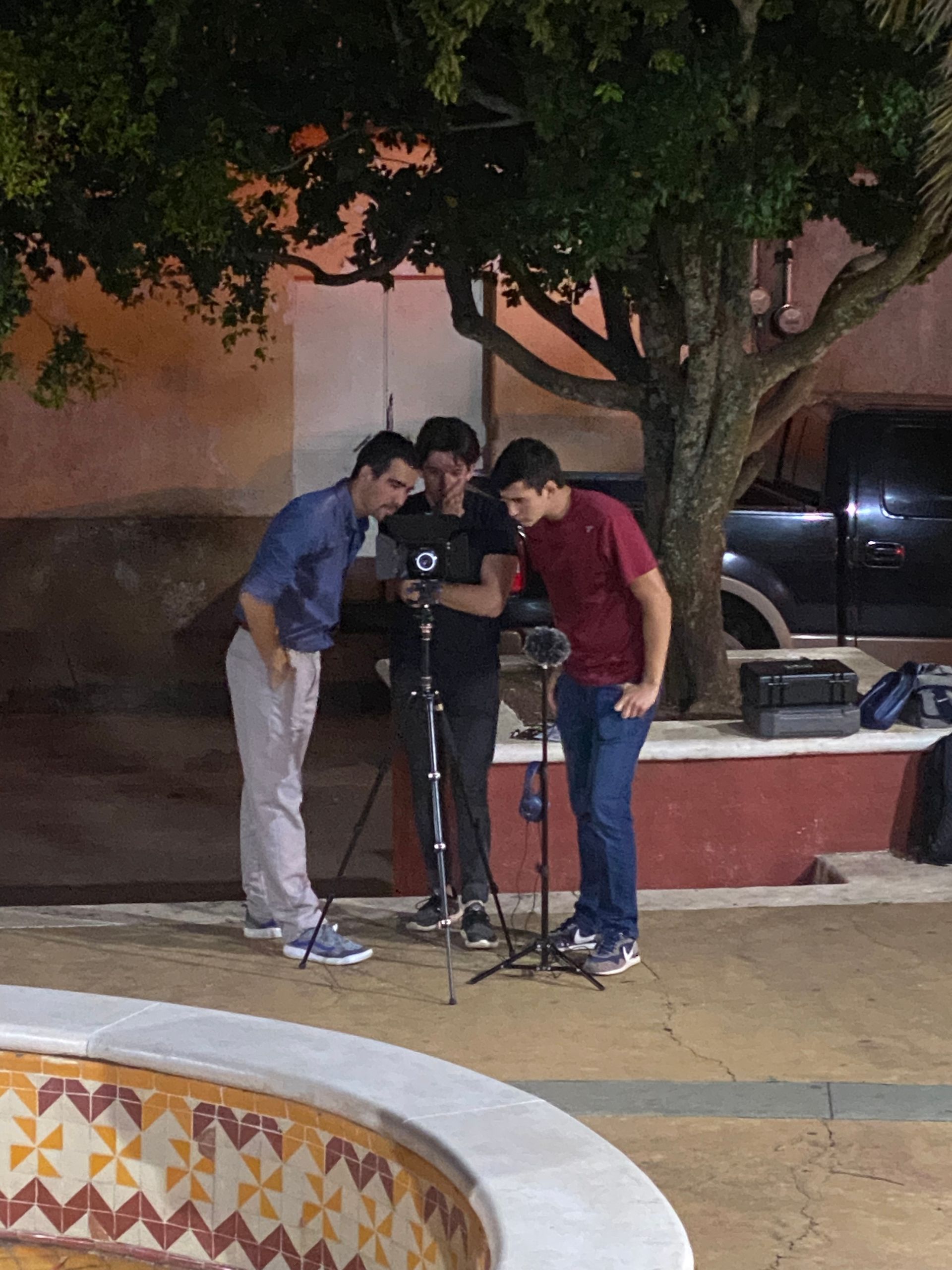Un grupo de hombres está de pie alrededor de una fuente mirando a una cámara.