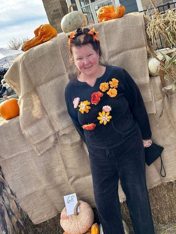 A woman wearing a black sweater with flowers on it