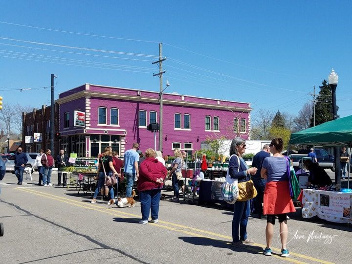 A group of people are standing in front of a purple building