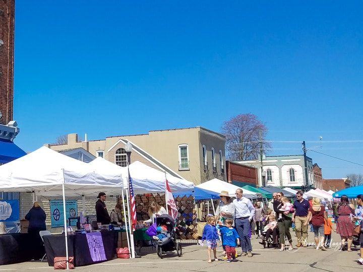 A group of people are walking around a street market