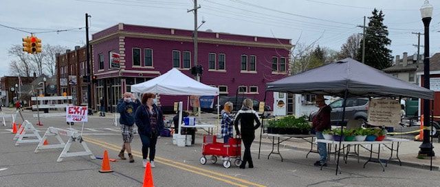 A group of people are standing in front of a purple building.