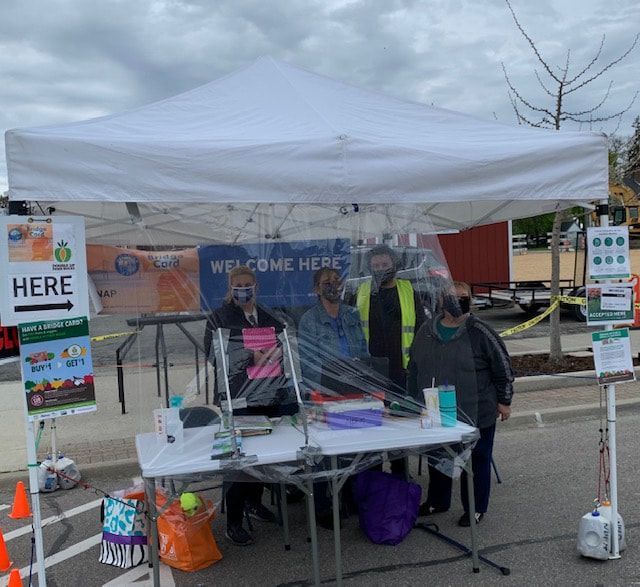A group of people standing under a tent that says welcome here
