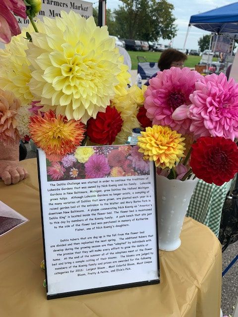 A table with flowers and a sign that says farmers market