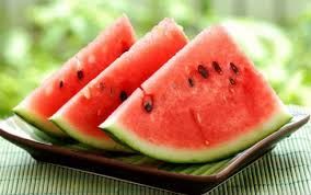Three slices of watermelon are on a plate on a table.