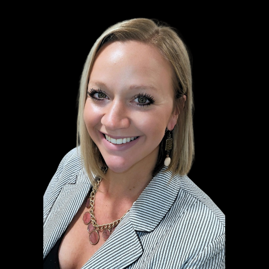 A woman wearing a striped jacket and a necklace is smiling for the camera.