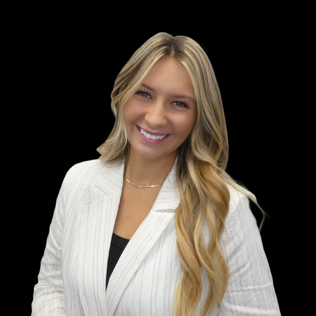 A woman in a white jacket is smiling for the camera