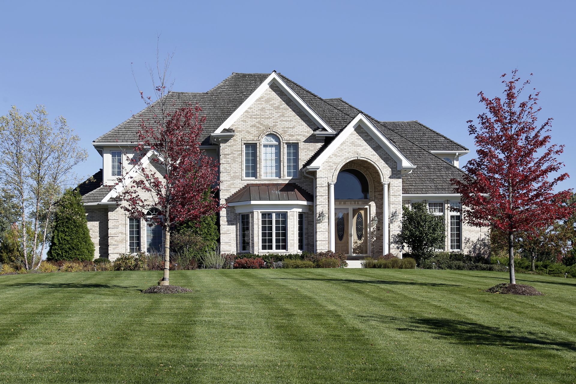 A large house with a lush green lawn in front of it