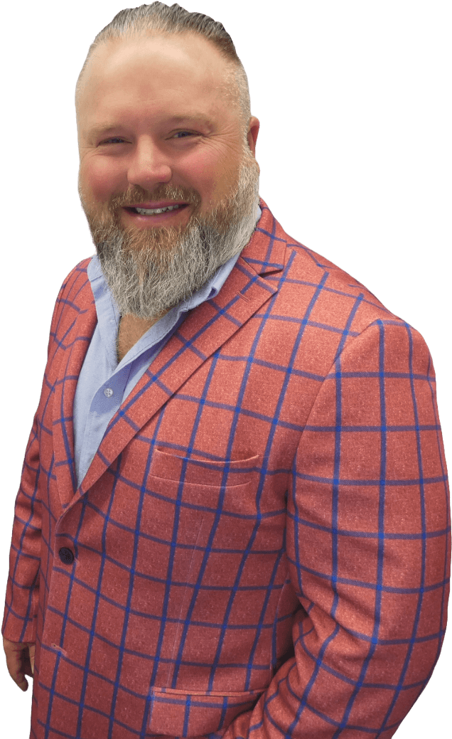 A man with a beard is wearing a red and blue plaid suit jacket.