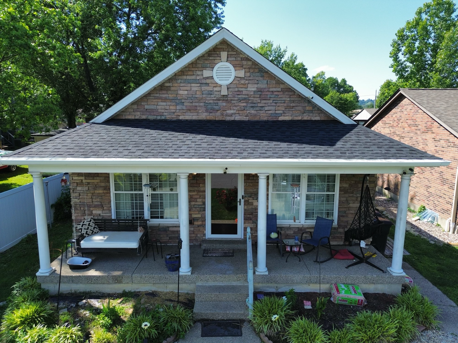 An aerial view of a brick house with a porch.