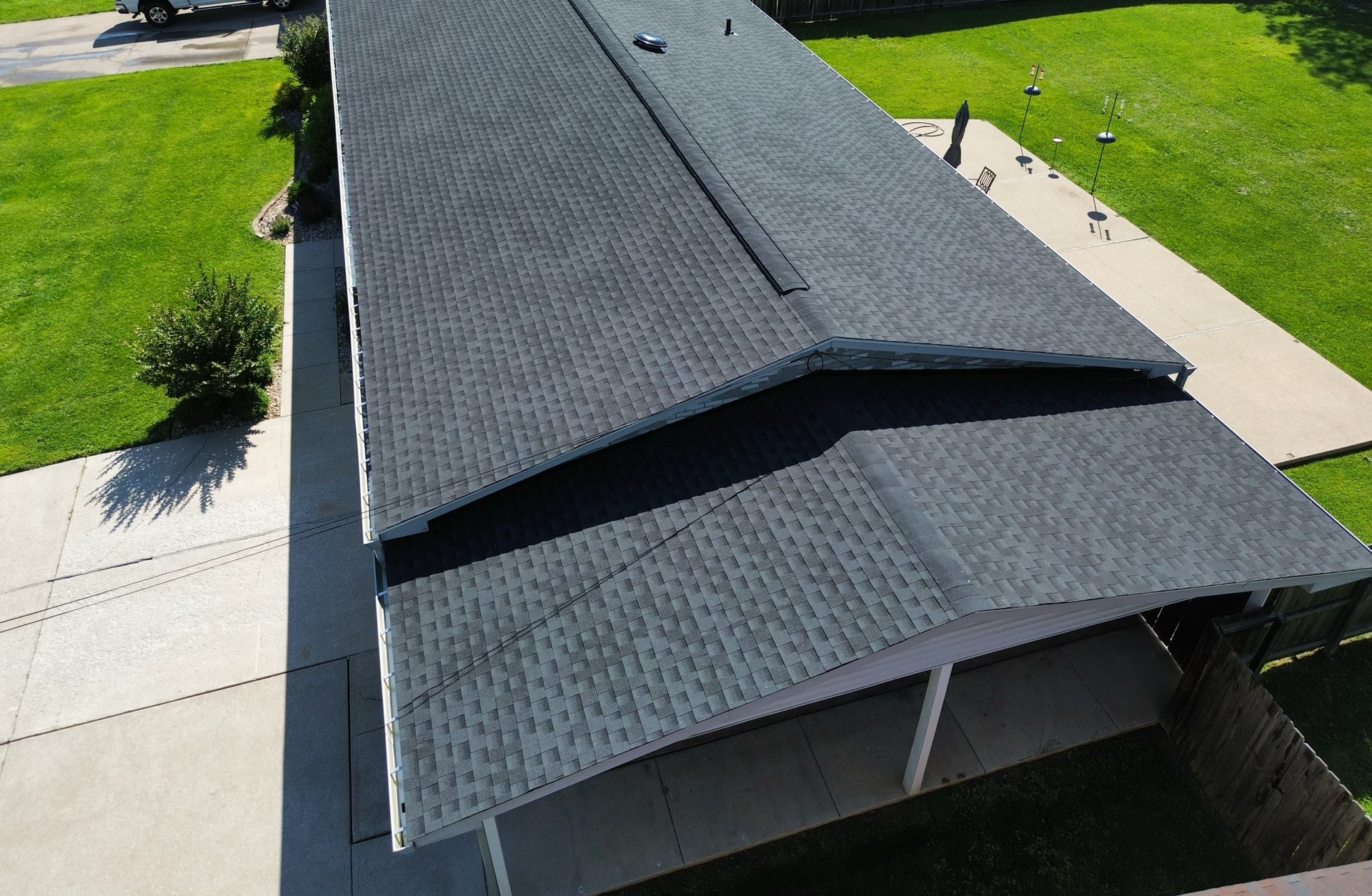 A roof with a lot of shingles on it is being installed on a house.