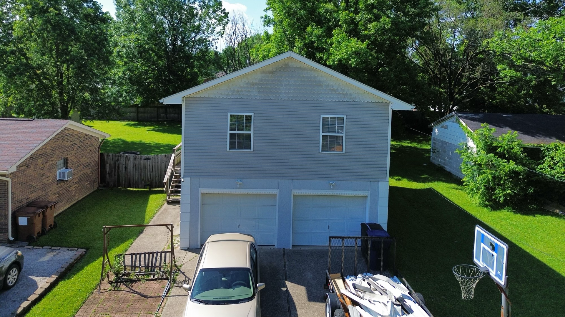 A house with a stone chimney on the side of it and a garage.