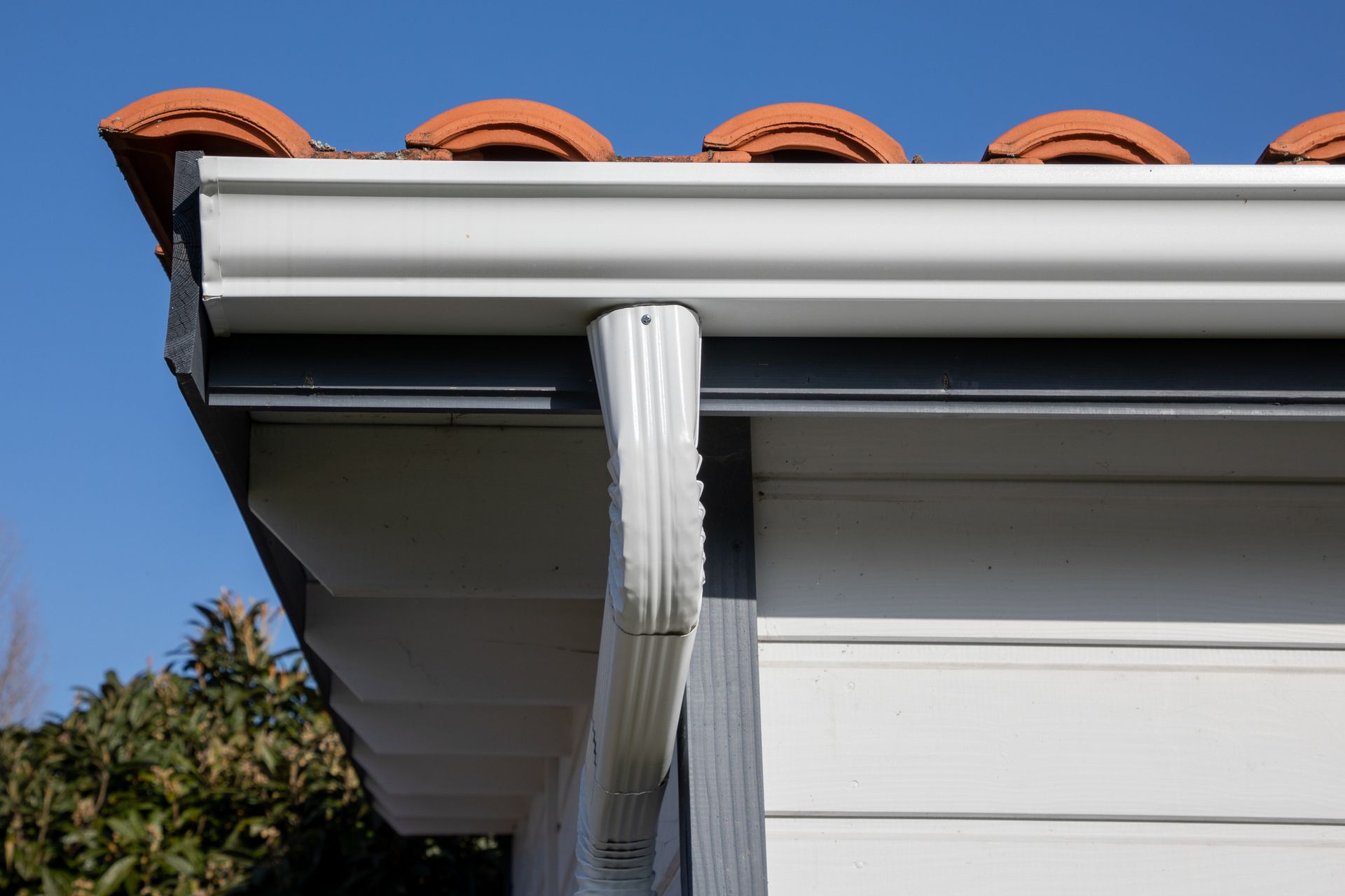A close up of a gutter on the side of a house.