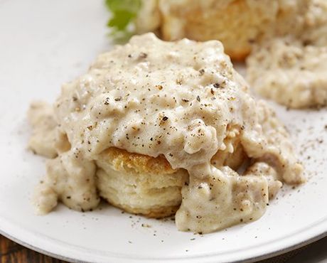 a white plate topped with a biscuit and gravy .