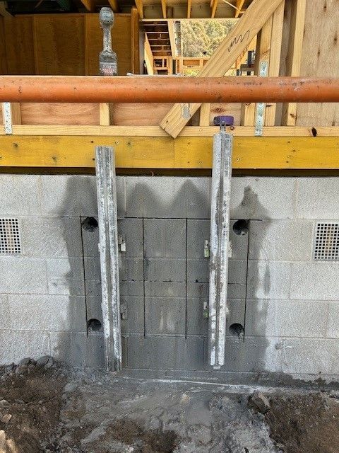 A concrete wall with holes in it is under construction