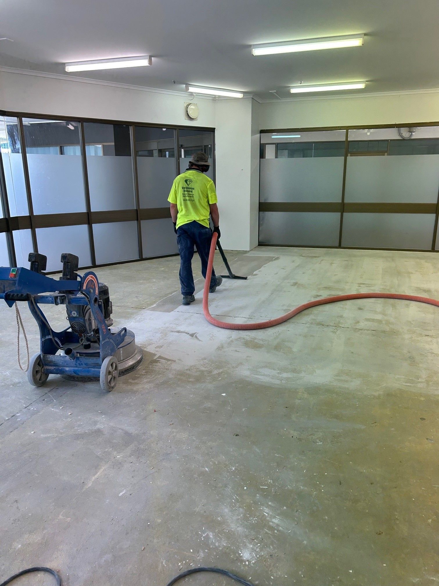 A man is using a machine to clean the floor of a building.