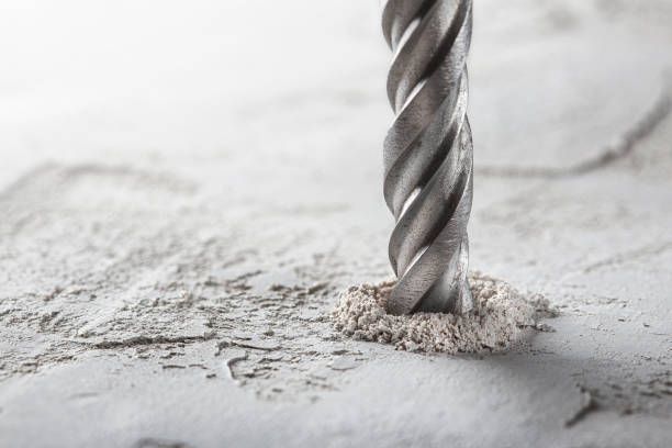 Close-up of a drill bit creating a hole in a surface, showcasing concrete core drilling services.