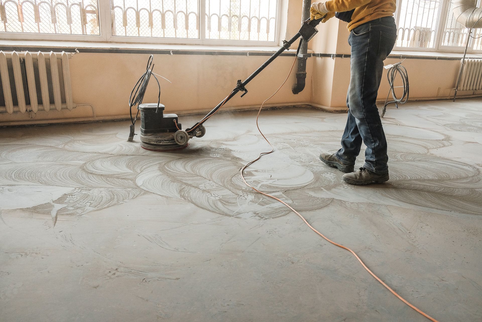 Workers grind the concrete floor on site for a smooth, durable finish.