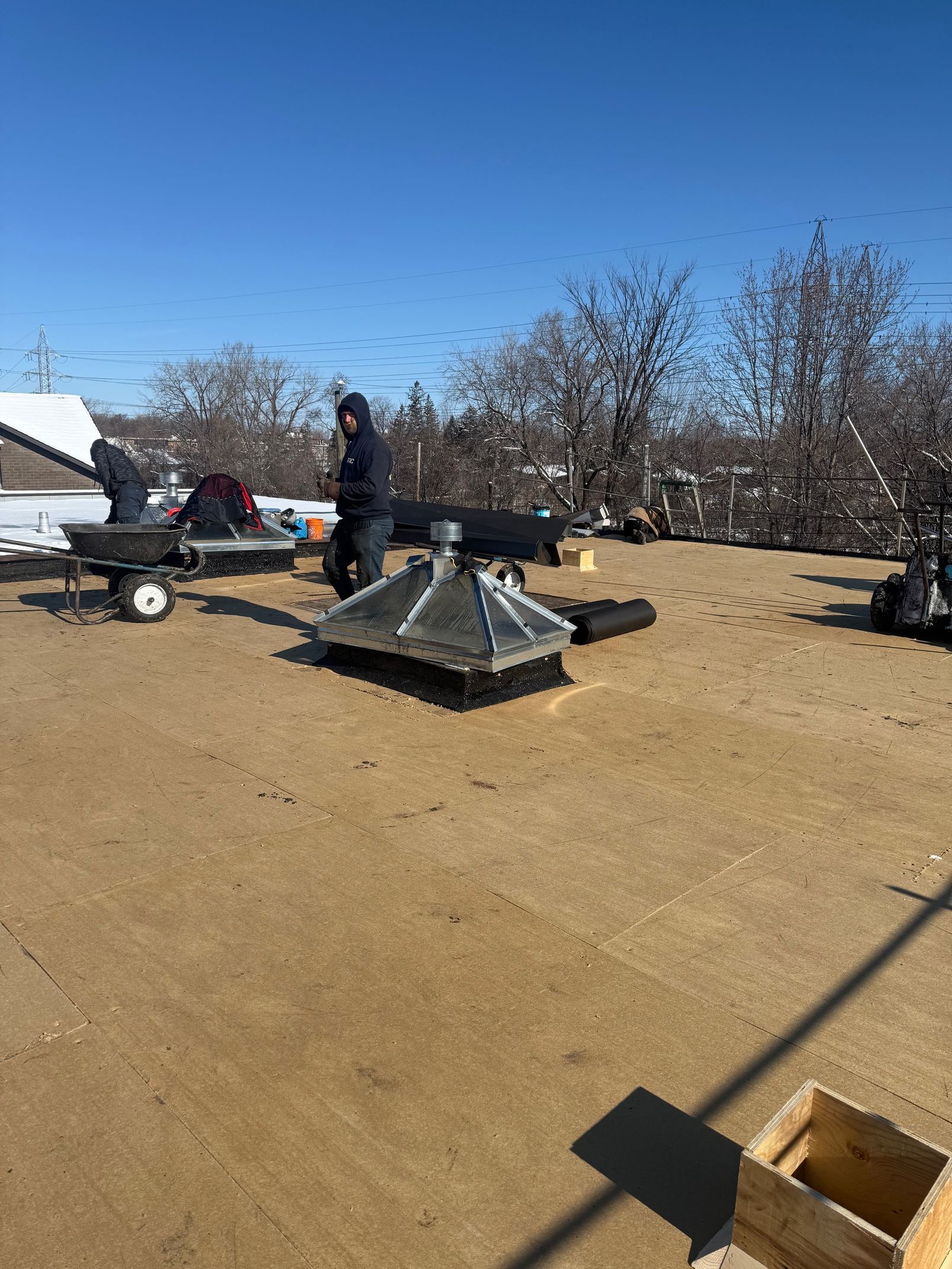 Un homme travaille sur le toit d'un immeuble.