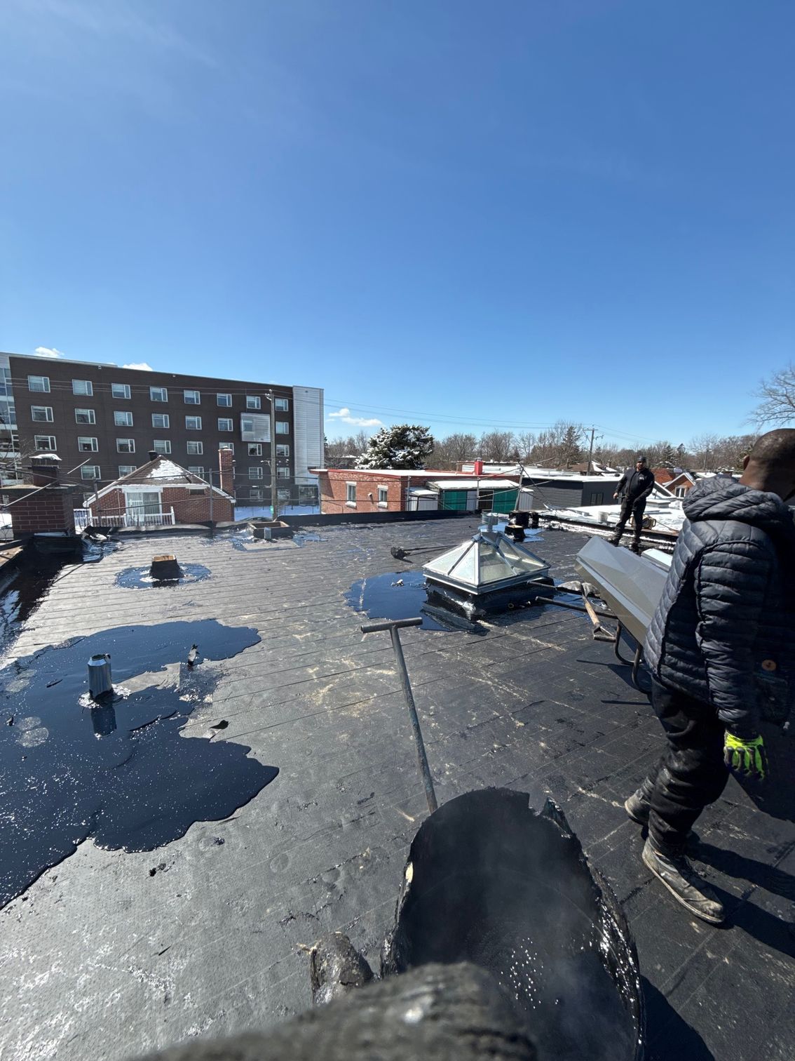 Un homme se tient sur le toit d'un immeuble.