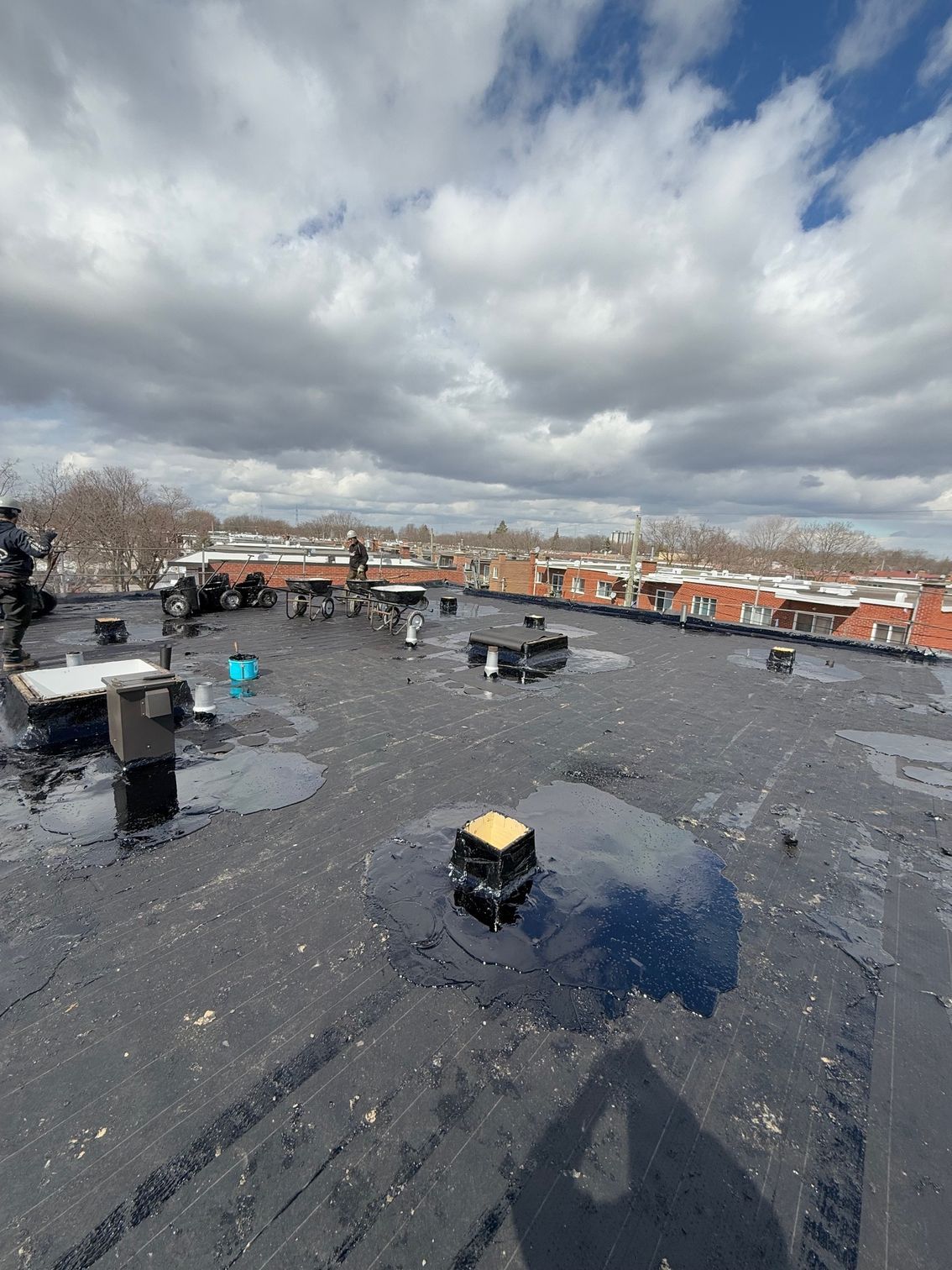 Un toit avec beaucoup de drains dessus et un ciel nuageux en arrière-plan.