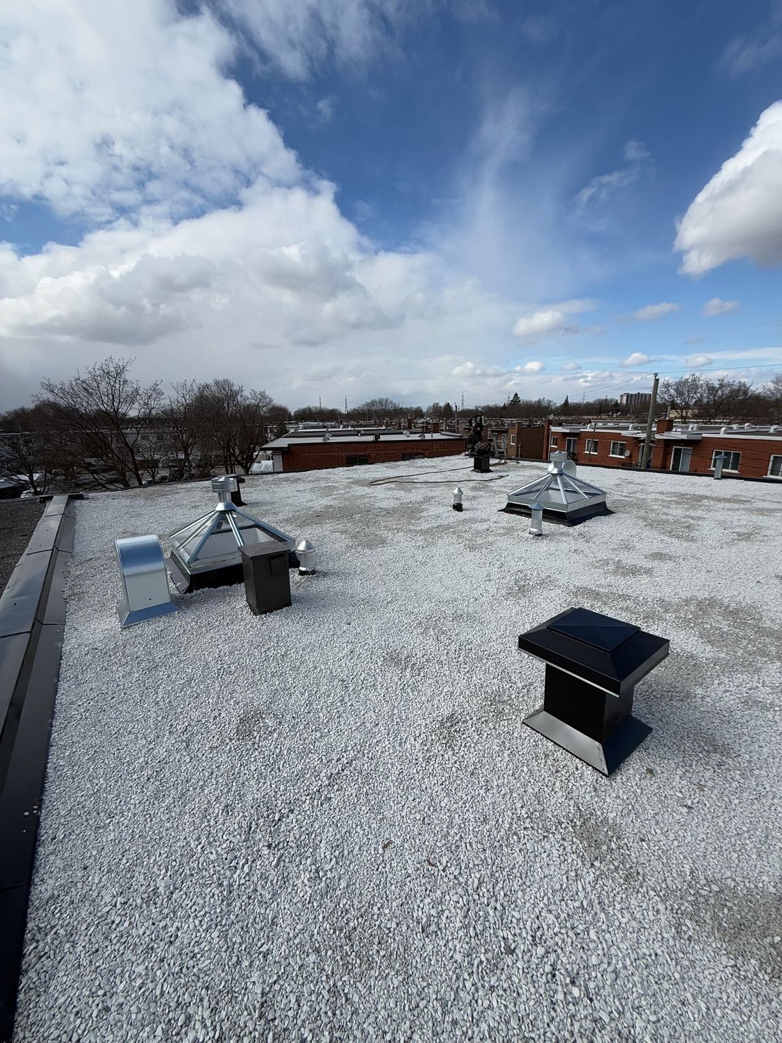Un toit avec beaucoup d'aérations et un ciel bleu en arrière-plan.