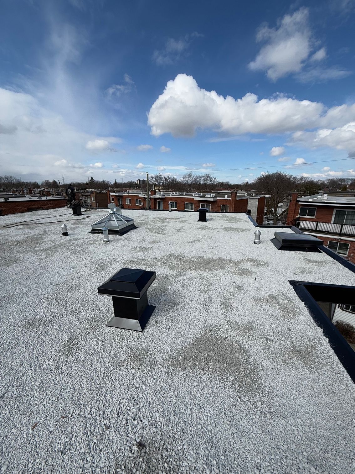Un toit avec beaucoup de gravier dessus et un ciel bleu en arrière-plan.