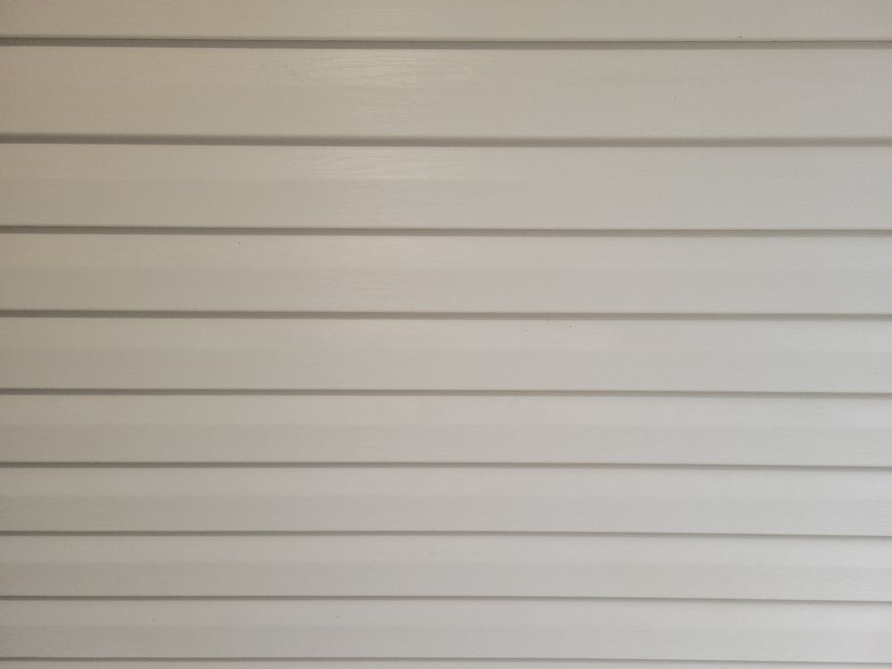 A close up of a white siding wall.