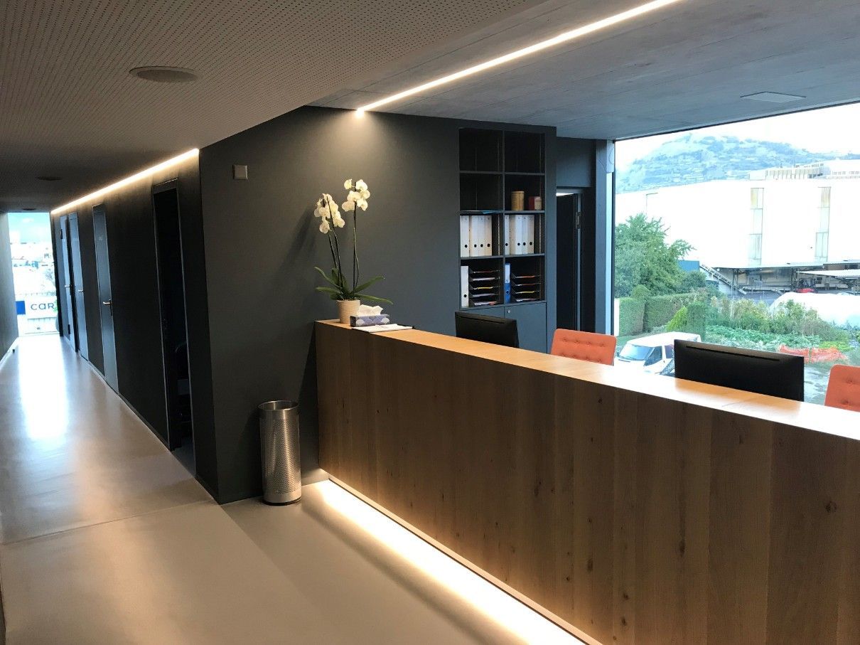 Un long couloir avec un bureau en bois et une fenêtre